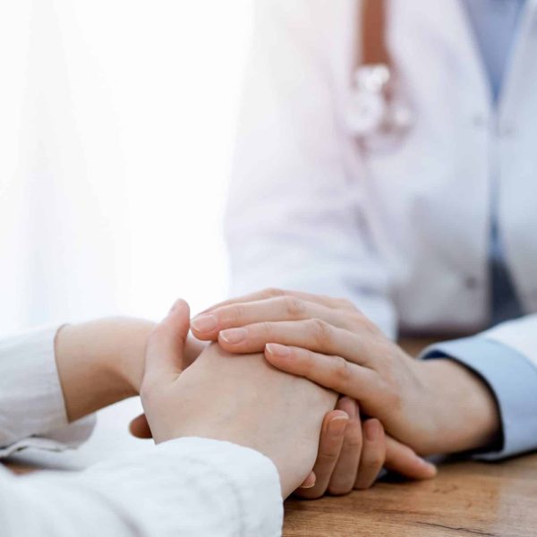 Doctor,And,Patient,Sitting,At,The,Wooden,Table,In,Clinic. Doctor,And,Patient,Sitting,At,The,Wooden,Table,In,Clinic.
